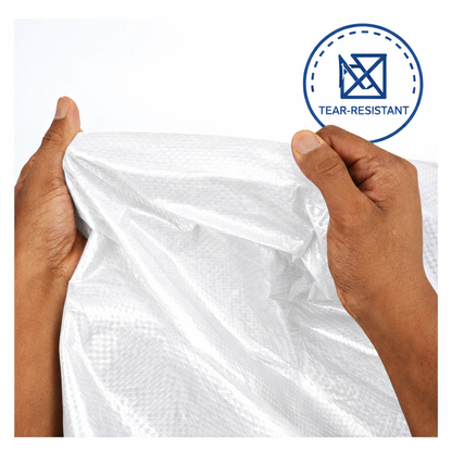 White heavy-duty tarp covering large outdoor equipment and materials
