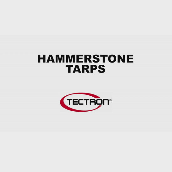 White heavy-duty tarp covering large outdoor equipment and materials
