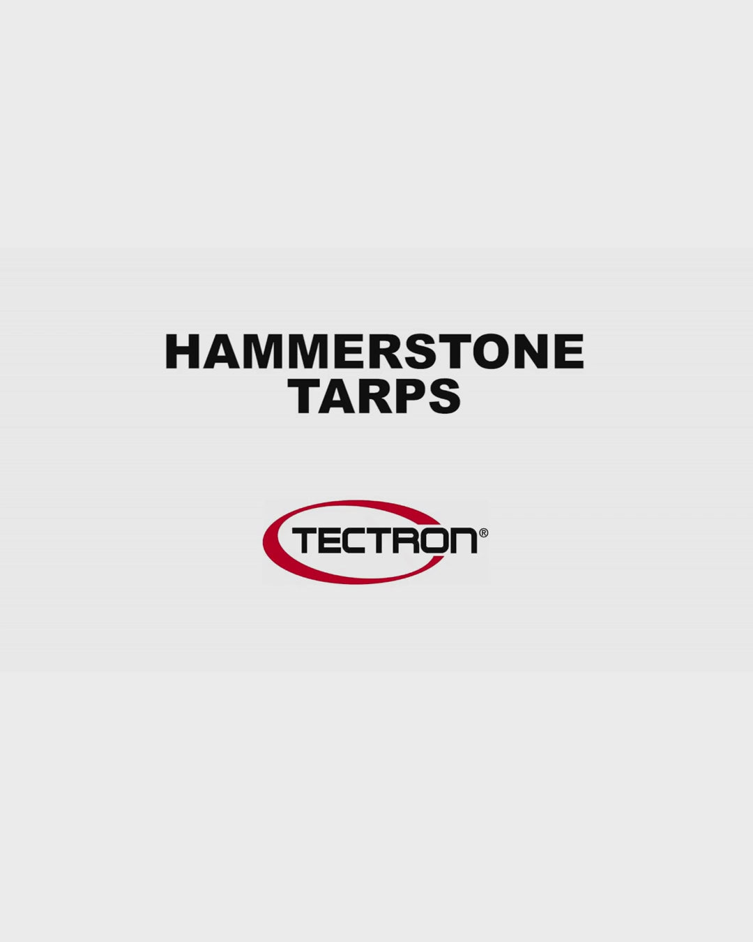 White heavy-duty tarp covering large outdoor equipment and materials
